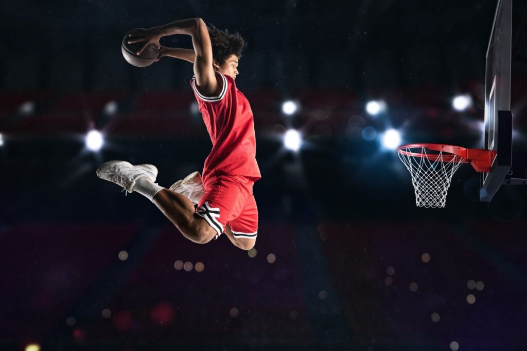 Un garçon noir en plein saut pour marquer un panier de basket