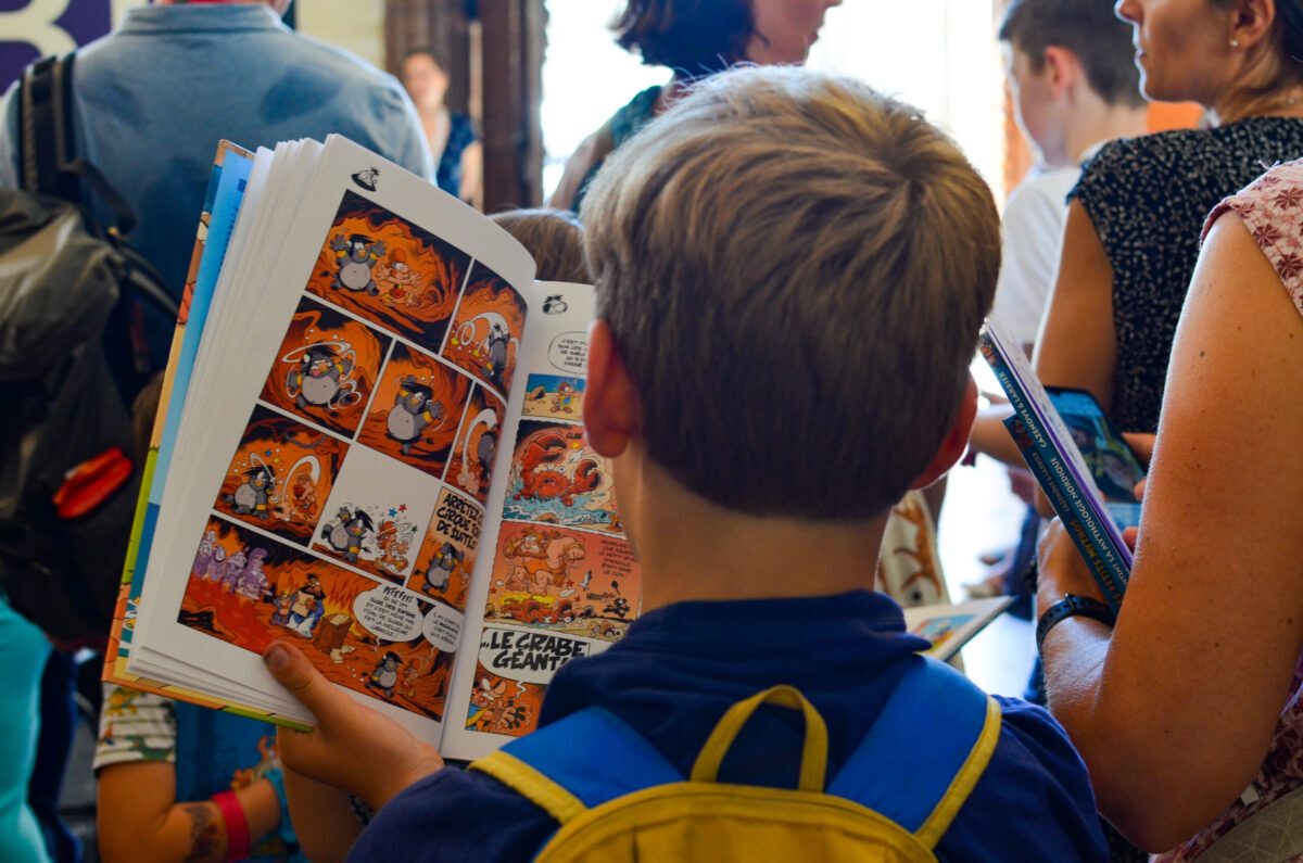petite garçon en pleine lecture de BD au Lyon BD Festival
