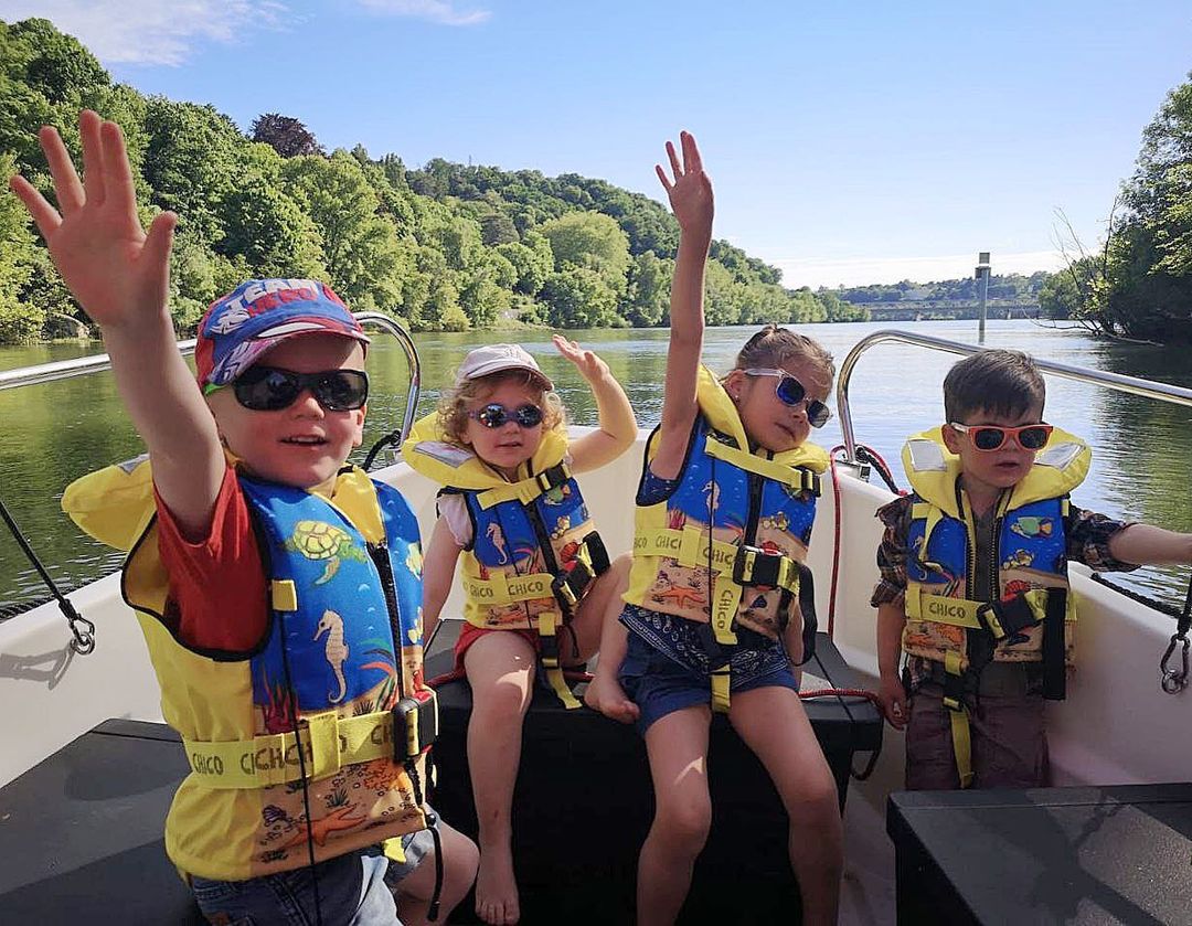 Des enfants en gilets de sauvetage à bord d'un bateau sur la Saône