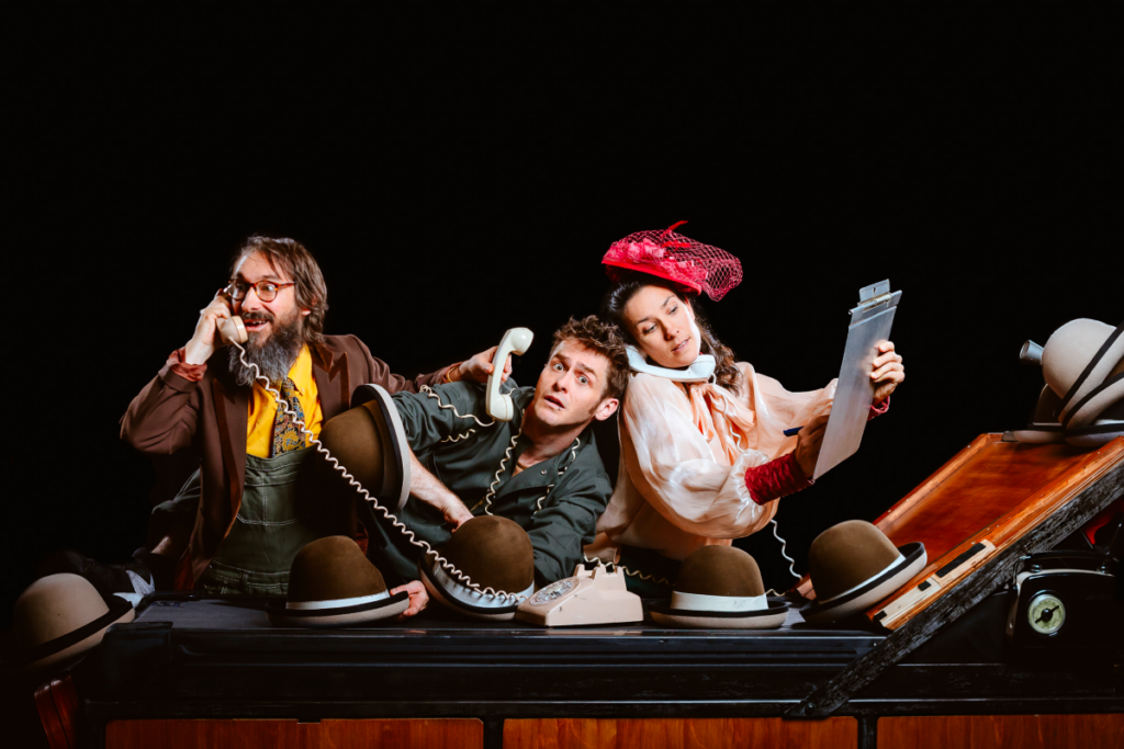 Trois comédiens circassiens au téléphone et devant des chapeaux dans le spectacle Robot infidèle de la compagnie Machine de Cirque 