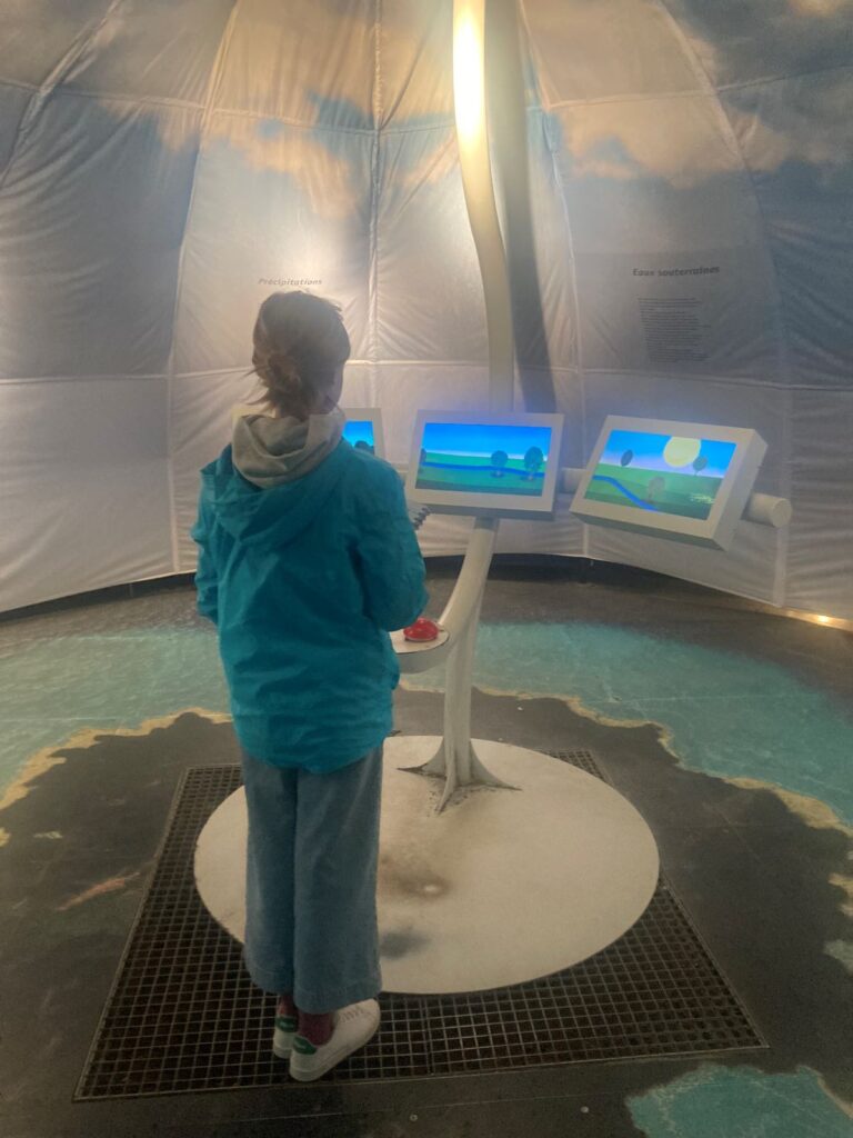 enfant devant l'une des animations interactives du musée de l"eau